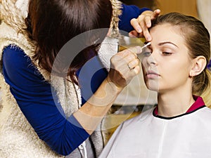 Woman getting eyes make up done by artist