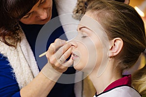 Woman getting eyes make up done by artist