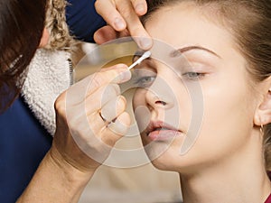 Woman getting eyes make up done by artist