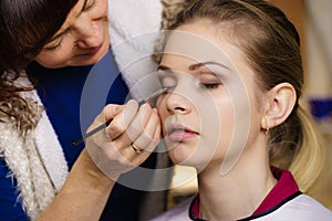 Woman getting eyes make up done by artist