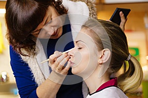 Woman getting eyes make up done by artist