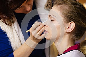 Woman getting eyes make up done by artist