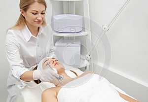 Woman getting face beauty treatment in medical spa center