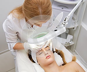 Woman getting face beauty treatment in medical spa center