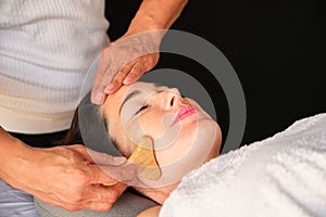 Woman getting face maderotherapy in a beauty salon. photo