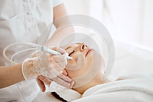 Woman getting face peeling procedure in beauty centre. Facial gas liquid peeling