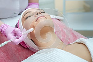 Woman getting face peeling procedure in a beauty SPA salon
