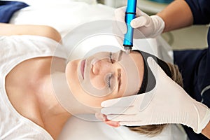 Woman getting facial hydro microdermabrasion peeling treatment at spa center. Hydra Vacuum Cleaner. Exfoliation, Rejuvenation And