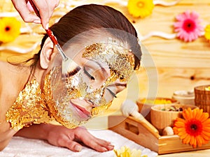 Woman getting facial mask .