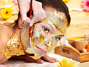 Woman getting facial mask .