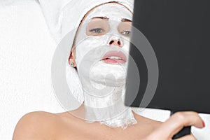 Woman getting facial mask in spa