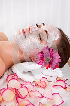 Woman getting facial mask at spa studio