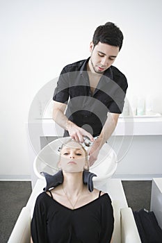 Woman Getting Hair Wash From Hairstylist In Parlor