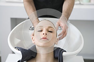 Woman Getting Hair Wash From Hairstylist In Salon photo