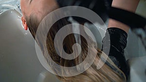 Woman getting head massage while washing hair in hairdressing salon Close up hairdresser doing head massage with