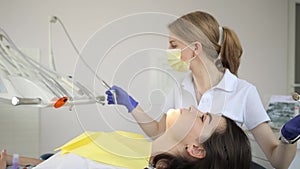 A woman is getting her teeth examined by a dentist in a dental office