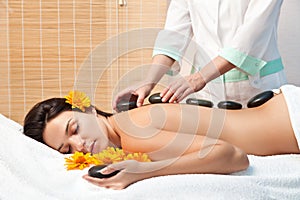 Woman getting a hot stone massage at spa salon