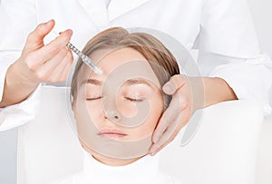 Woman is getting injection. Anti-aging treatment and face lift. Facial skin lifting injection to woman`s face