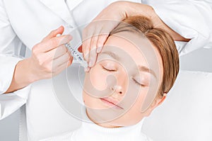 Woman is getting injection. Anti-aging treatment and face lift. Facial skin lifting injection to woman`s face