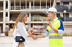 Woman getting keys to new apartment from enginner