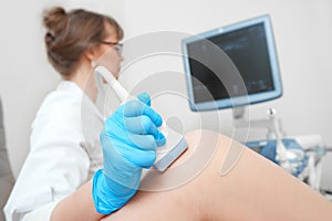 Woman getting knee ultrasound scanning examination at the clinic