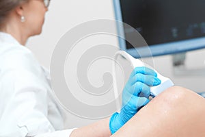 Woman getting knee ultrasound scanning examination at the clinic