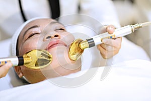 Woman getting laser and ultrasound face treatment in medical spa center. skin rejuvenation concept. woman laying eyes closed, rece