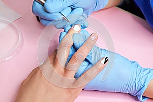 Woman is getting manicure in beauty salon.