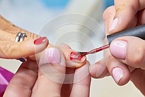 Woman is getting manicure in beauty salon.