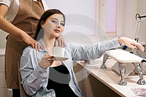 Woman getting manicure and massage at the same time in a salon