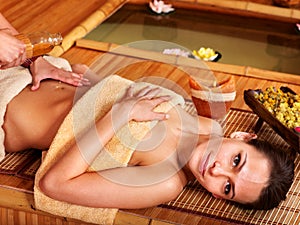 Woman getting massage in bamboo spa.