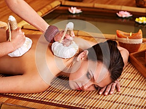 Woman getting massage in bamboo spa.