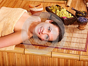 Woman getting massage in bamboo spa.