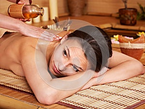 Woman getting massage in bamboo spa.