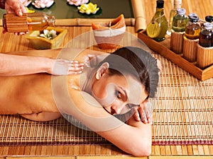 Woman getting massage in bamboo spa.