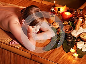 Woman getting massage in bamboo spa.