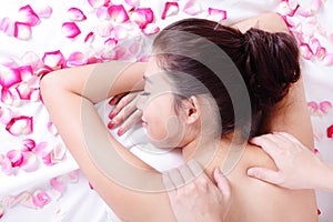 Woman getting massage and spa treatment with rose