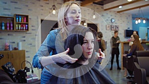 Woman getting new haircut by hairdresser at parlor