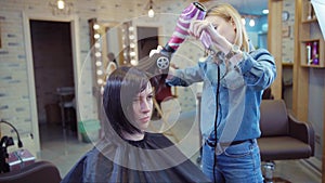 Woman getting new haircut by hairdresser at parlor