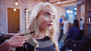 Woman getting new haircut by hairdresser at parlor