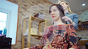 Woman getting new haircut by hairdresser at parlor