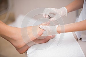 Woman getting a pedicure from beautician