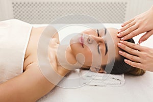 Woman getting professional facial massage at spa salon