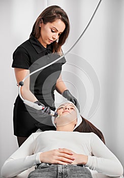Woman getting radiofrequency microneedling treatment in clinic.