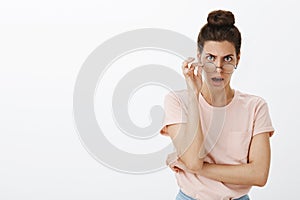 Woman getting shocked and insulted of misbehaviour taking off glasses looking from under forehead with frown dropping