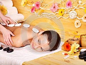 Woman getting stone therapy massage .