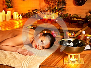 Woman getting stone therapy massage .