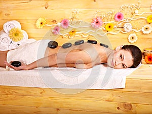 Woman getting stone therapy massage .