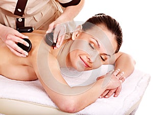 Woman getting stone therapy massage .