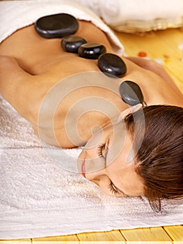 Woman getting stone therapy massage .